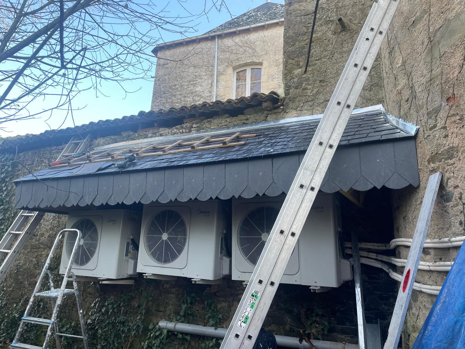 Auvent en ardoises taillées en écailles, rive en zinc