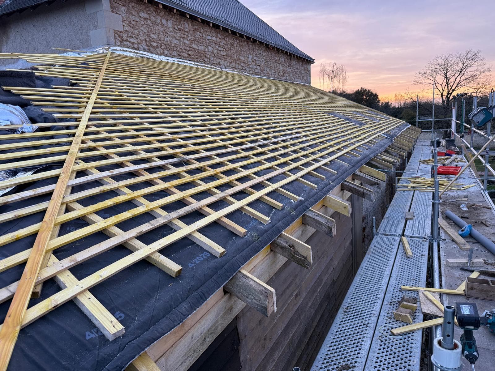 Pannes et chevrons neufs sur une grange en pierre