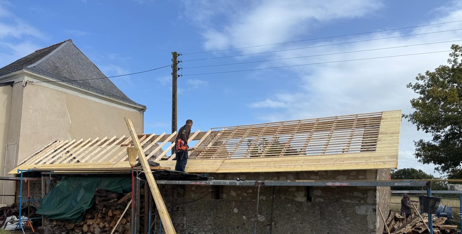 Un versant voligé, l'autre en claire-voie : chantier en cours